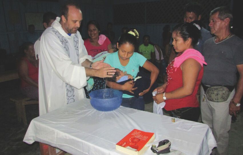 El padre César Caro durante un bautismo.