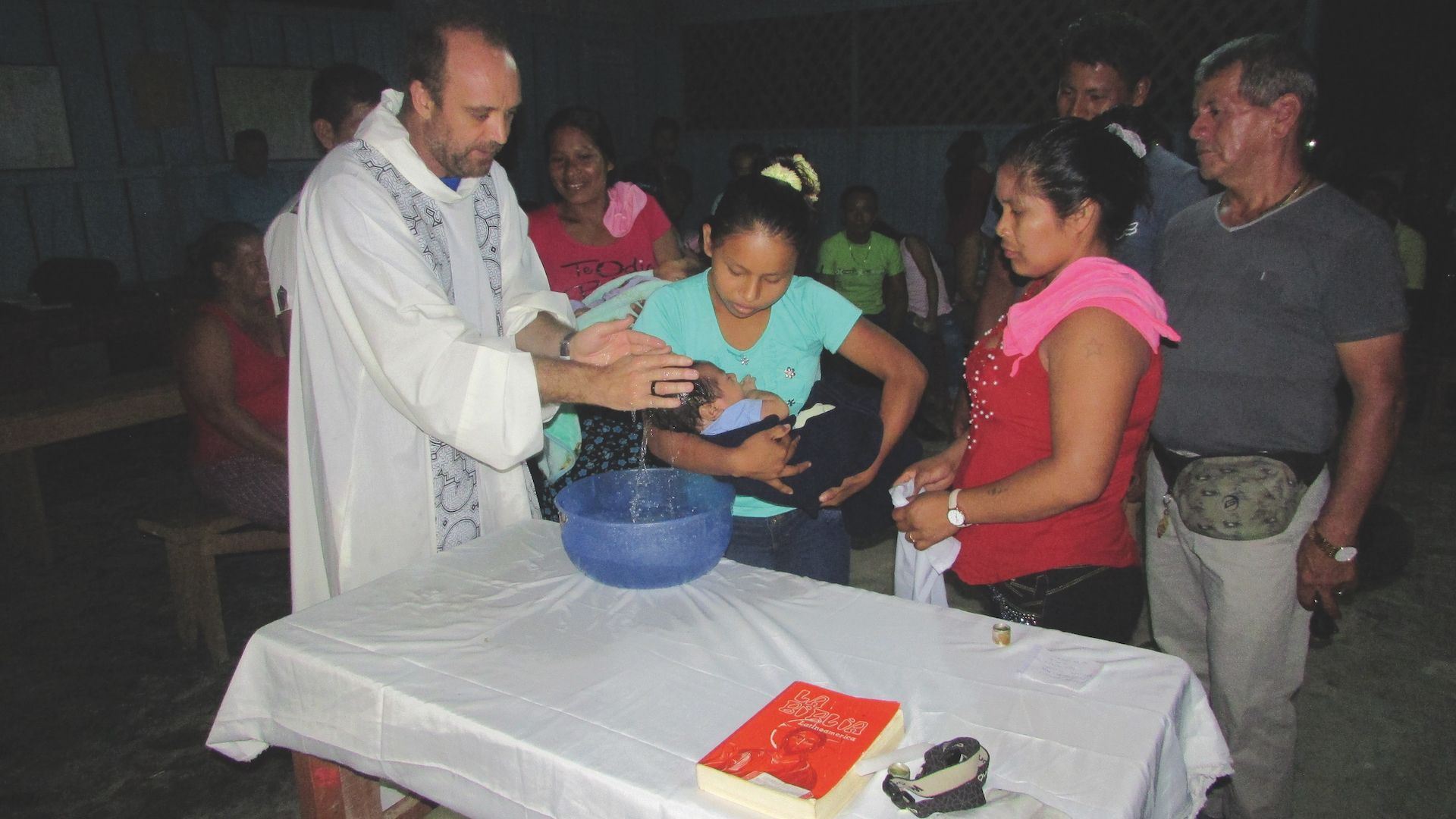 El padre César Caro durante un bautismo.